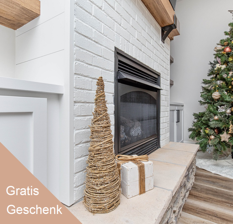 Weihnachtsbaum neben einem Kamin mit Deko und Geschenkboxen.