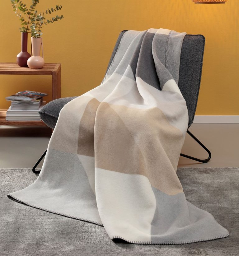 Junge Frau sitzt auf einem Hocker und freut sich, mit Auszeichnung German Design Award Gold 2024.