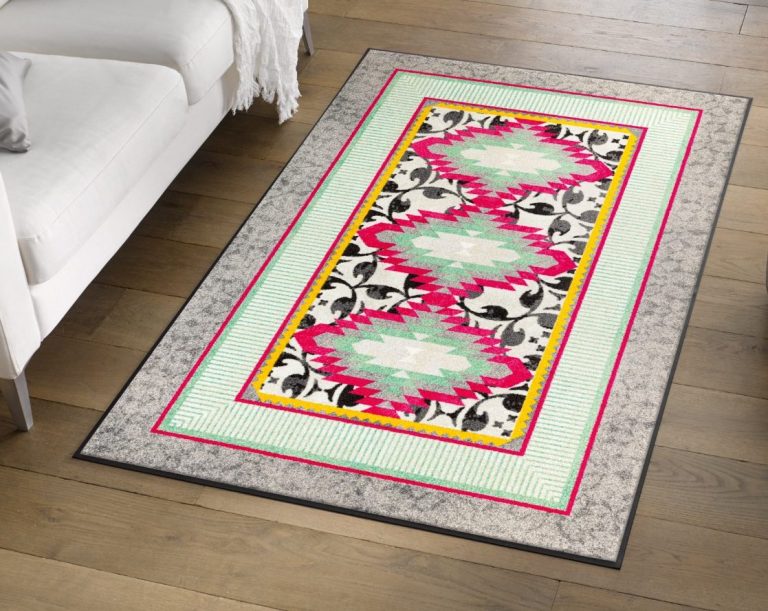 Bunter Teppich mit geometrischen Mustern in Pink, Grün und Schwarz auf Holzboden.