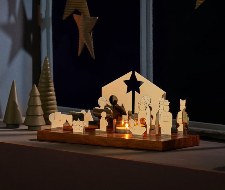 Holzschnitzereien einer Weihnachtskrippe mit weiteren dekorativen Figuren und Sternen.