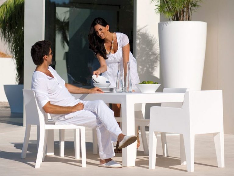 Weiße Designerliege in moderner Architektur neben einem Pool.