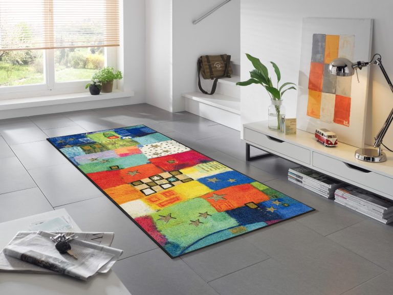 Bunt gemusterter Teppich in modernem Raum mit Holzfenstern und minimalistischem Möbel.